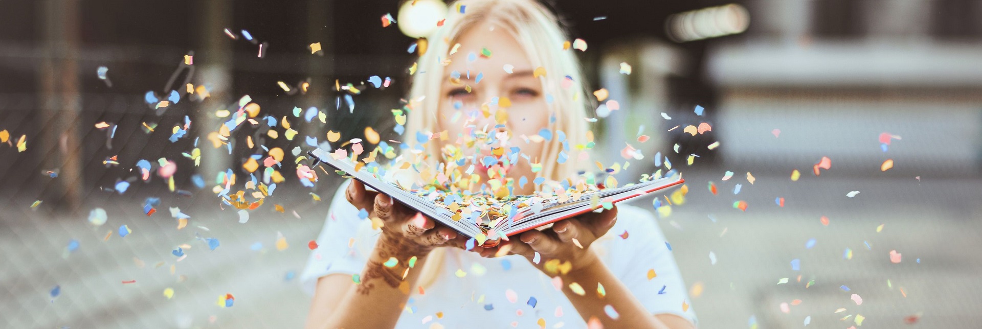 Frau pustet Konfetti aus Buch